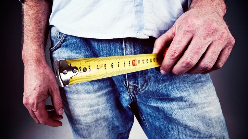 Man measuring penis after enlargement with gel.